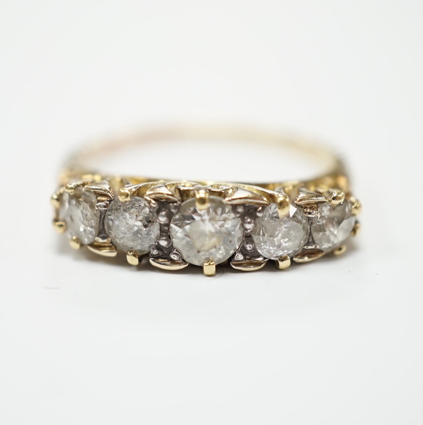 A yellow metal and graduated five stone diamond set half hoop ring, size Q, gross weight 3.9 grams.